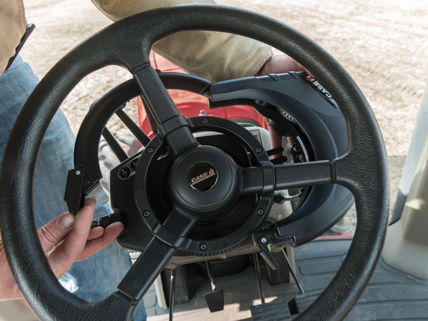 A person attaching new components onto a steering wheel on a sunny day.